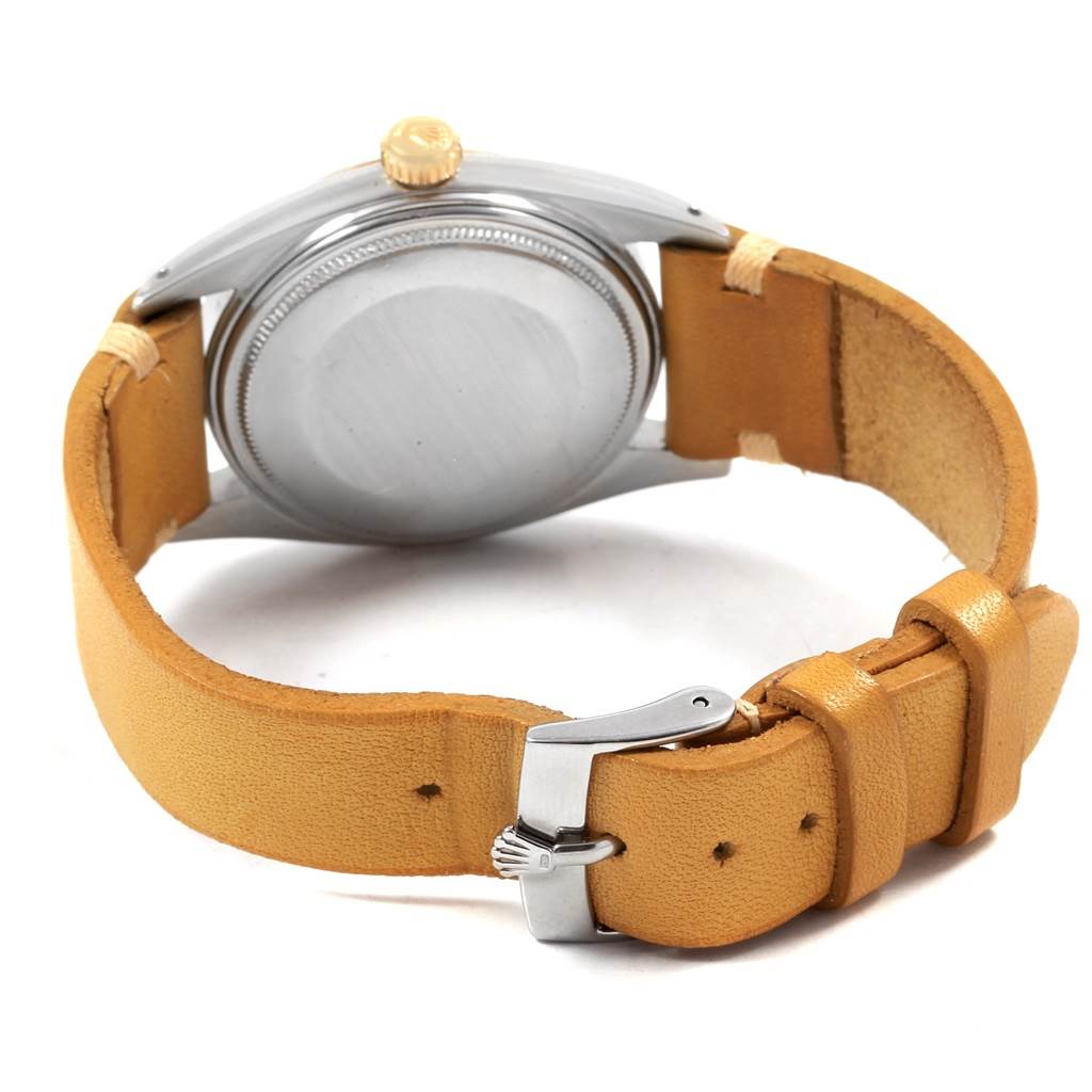 The image shows the back view of a Rolex Vintage Collection 1601 Men's Steel and Gold (two tone) Champagne Dial 1601 Men's Steel and Gold (two tone) Champagne Dial watch with a tan leather strap and a metal buckle.