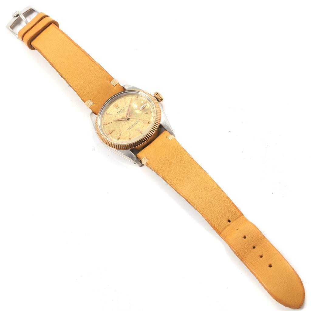 The image shows the Rolex Vintage Collection 1601 Men's Steel and Gold (two tone) Champagne Dial 1601 Men's Steel and Gold (two tone) Champagne Dial watch from a top-down angle, displaying its face, bezel, crown, case, and leather strap.