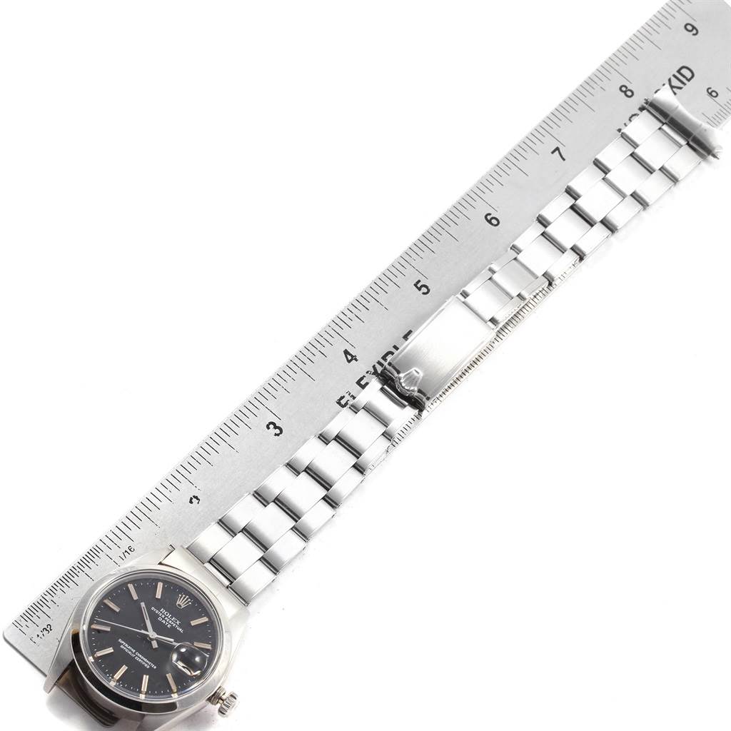 The image shows a Rolex Vintage Collection 1500 Men's Stainless Steel Black Dial 1500 Men's Stainless Steel Black Dial watch laid flat next to a ruler, displaying the face and metal bracelet.