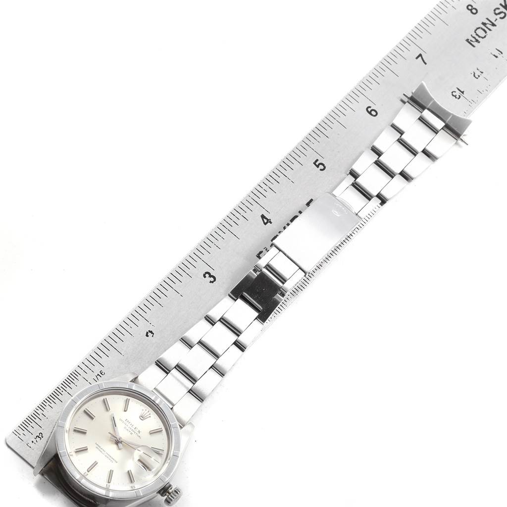 The image shows a top view of a Rolex Vintage Collection 1501 Men's Stainless Steel Silver Dial 1501 Men's Stainless Steel Silver Dial watch, displaying the face and stainless steel bracelet aligned next to a ruler.