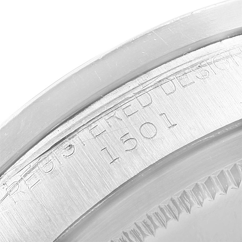 This close-up image shows the engraved serial number and part of the bezel on a Rolex Vintage Collection 1501 Men's Stainless Steel Silver Dial 1501 Men's Stainless Steel Silver Dial model.