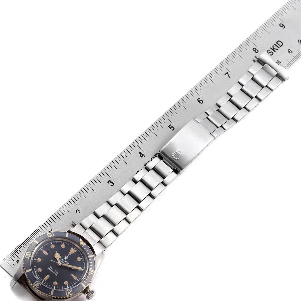 The image shows a Rolex Vintage Collection 5508 Men's Stainless Steel Black Dial 5508 Men's Stainless Steel Black Dial model watch laid flat alongside a ruler, highlighting the face and bracelet.