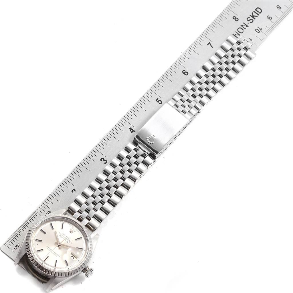 The Rolex Vintage Collection 1603 Men's Stainless Steel Silver Dial 1603 Men's Stainless Steel Silver Dial watch is shown from a top-down angle, displaying its face, bezel, and metal bracelet beside a ruler.
