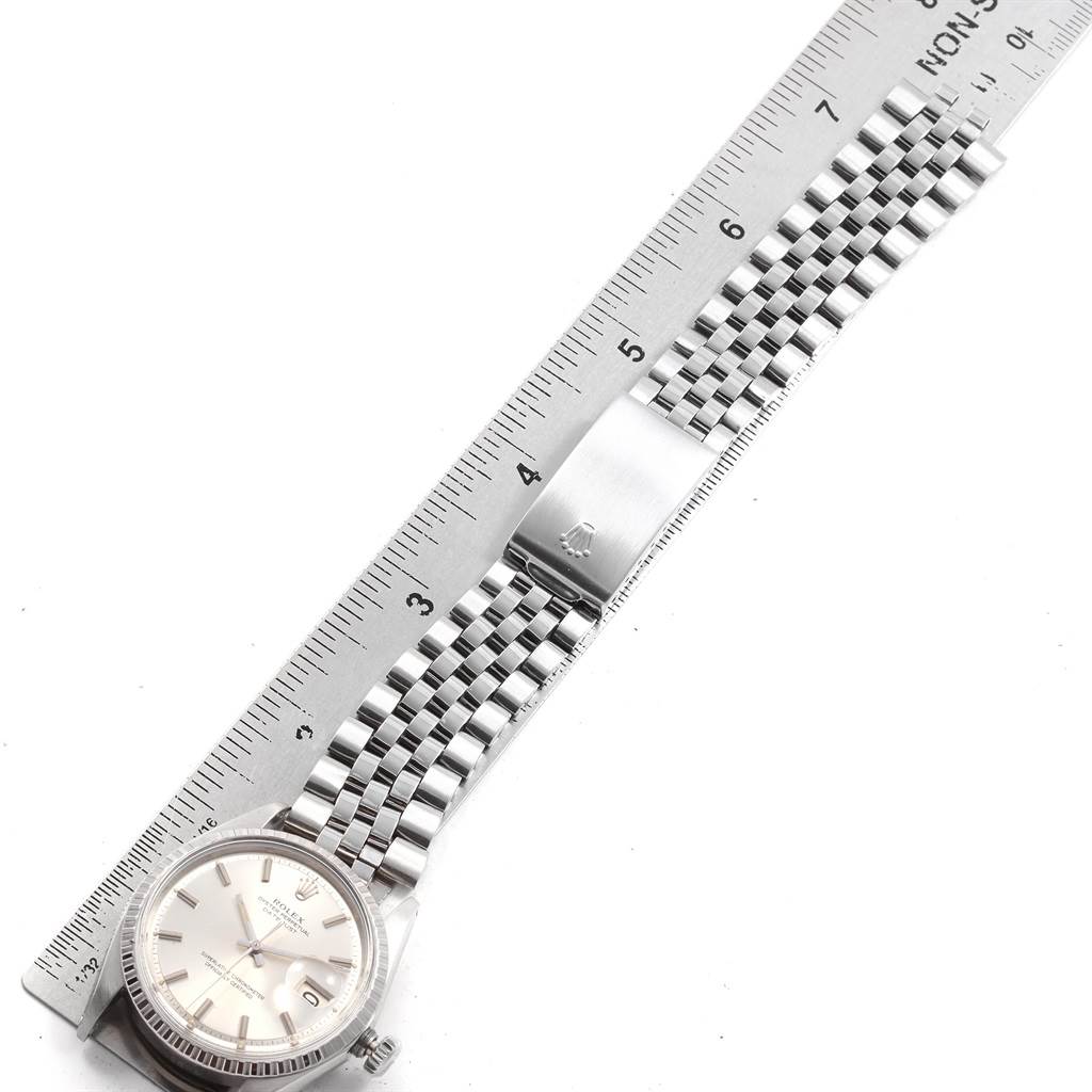 This image shows a Rolex Vintage Collection 1603 Men
s Stainless Steel Silver Dial 1603 Men
s Stainless Steel Silver Dial watch laid flat with the face, bracelet, and clasp visible, alongside a ruler for measurement.