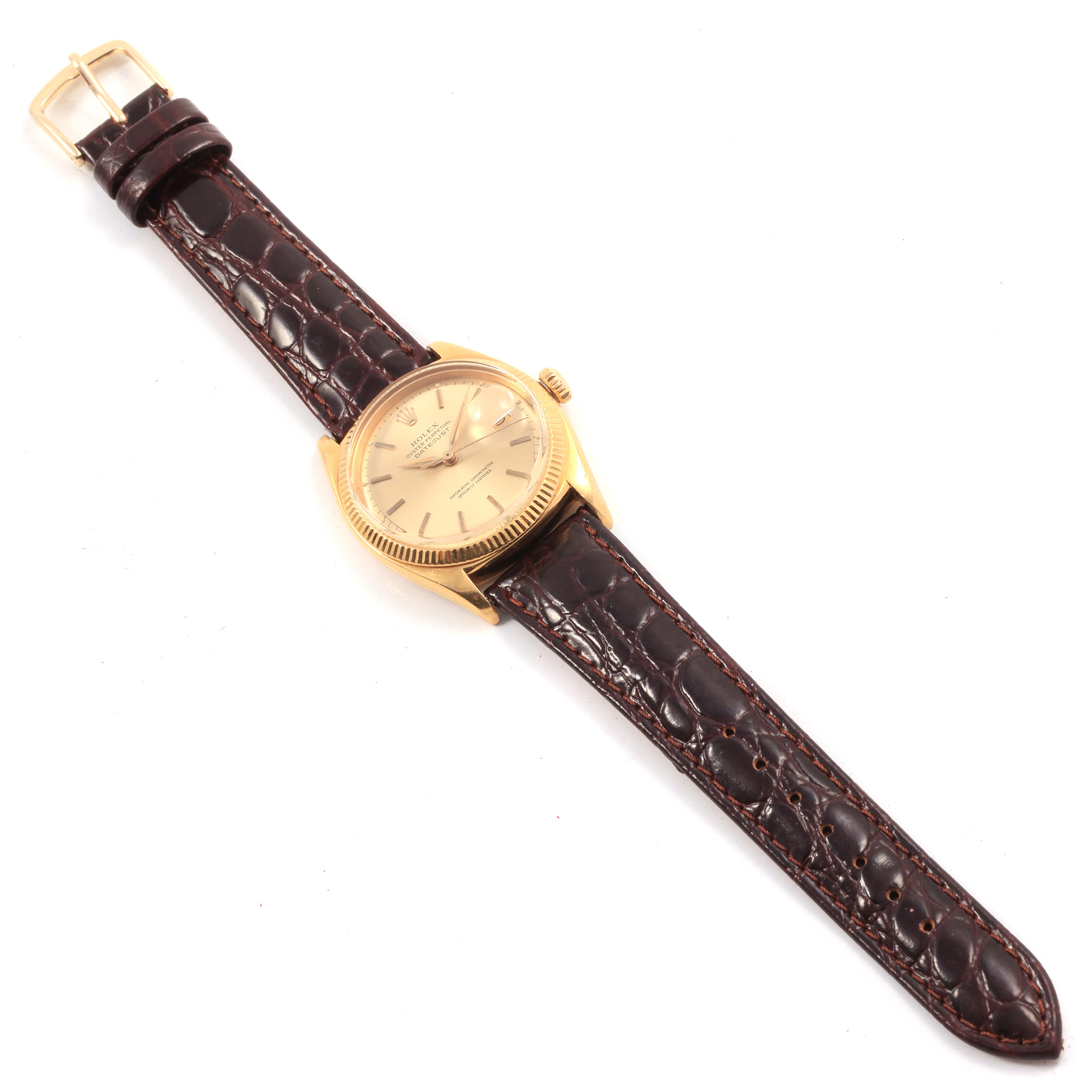 This image shows a top-down view of a Rolex Vintage Collection 6605 Men
s Yellow Gold Champagne Dial 6605 Men
s Yellow Gold Champagne Dial watch with a brown leather strap and gold casing.