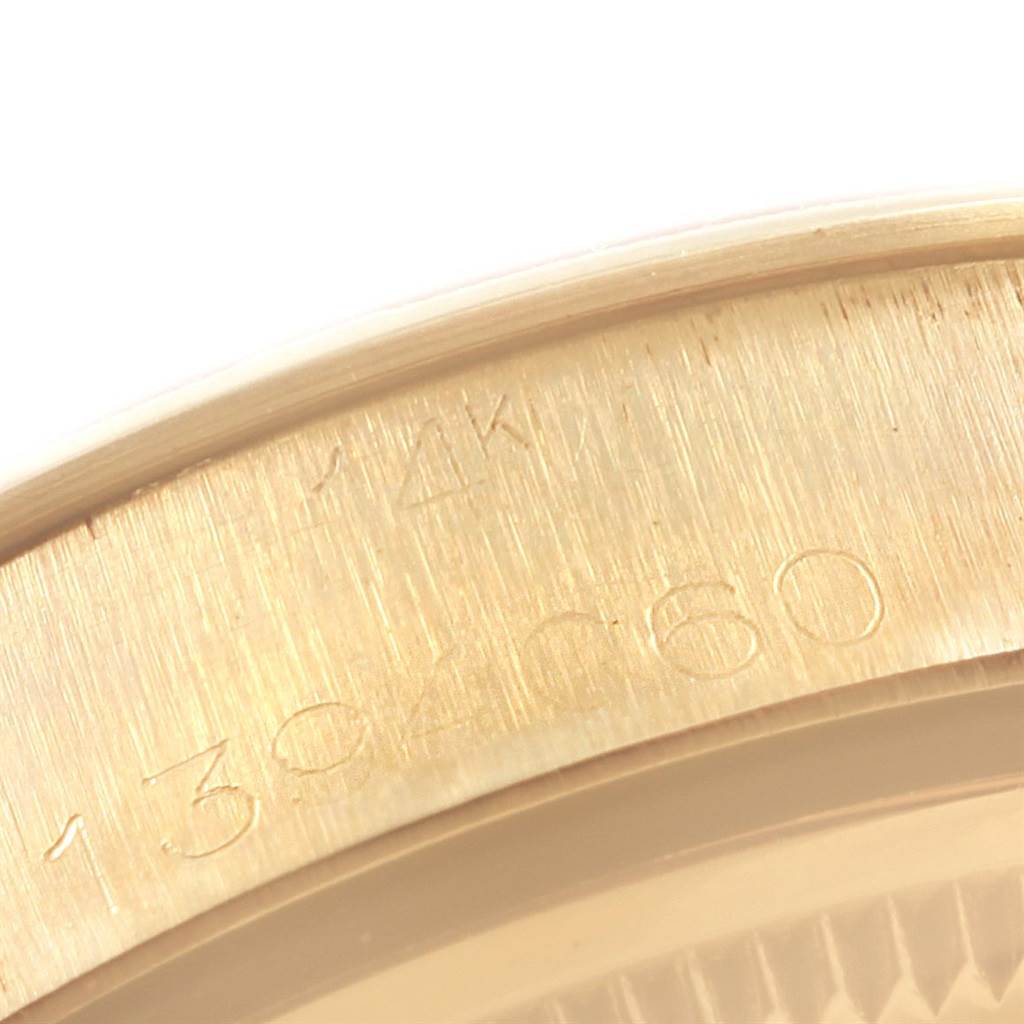 This close-up image of a Rolex Vintage Collection 1003 Men's Yellow Gold Silver Dial 1003 Men's Yellow Gold Silver Dial model shows a portion of the serial number engraved on the watch case.