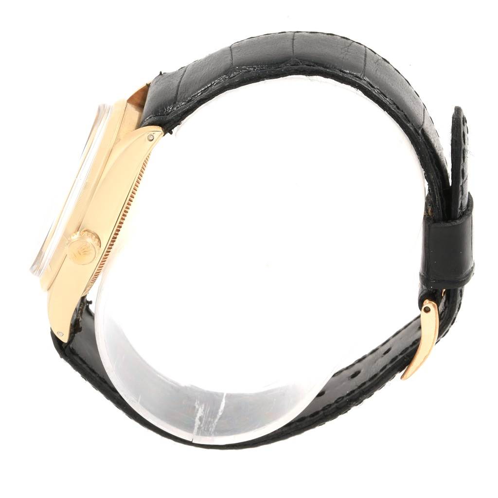 The image shows the side view of a Rolex Vintage Collection 1003 Men's Yellow Gold Silver Dial 1003 Men's Yellow Gold Silver Dial watch, highlighting the crown, case, and leather strap.