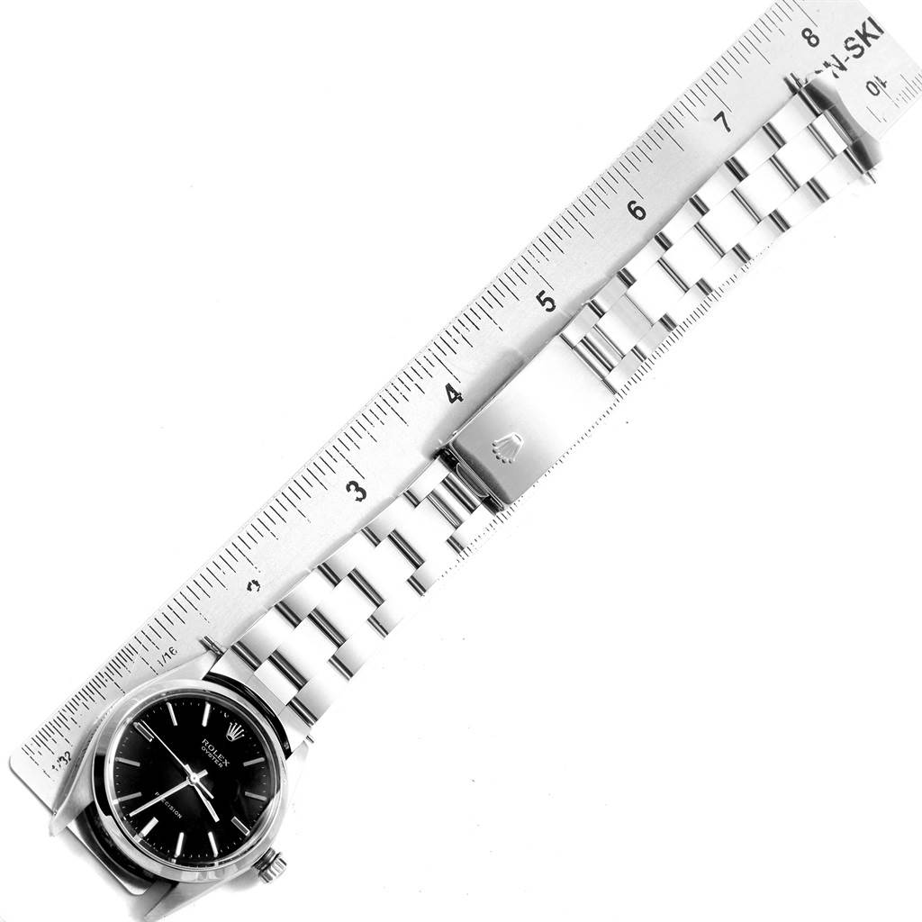 The Vintage Collection Rolex watch is shown flat with its dial, bracelet, and clasp aligned beside a ruler.
