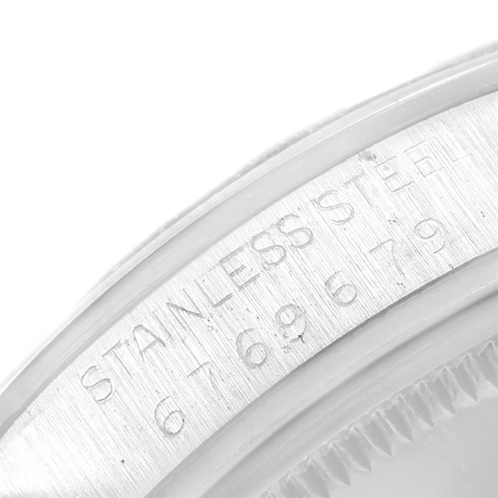 This close-up image of the Rolex Vintage Collection 15000 Men's Stainless Steel Black Dial 15000 Men's Stainless Steel Black Dial watch shows the steel bezel and part of the case with engraved serial numbers.