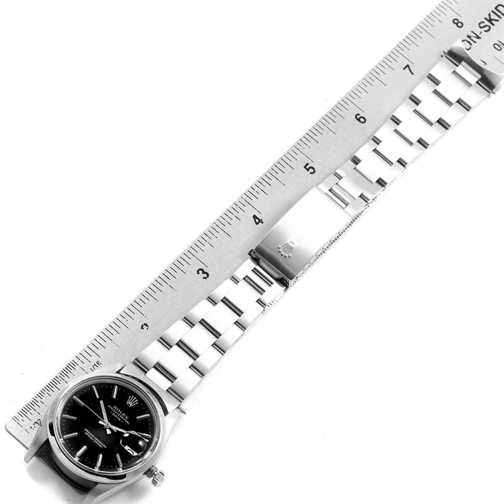 This image shows the Rolex Vintage Collection 15000 Men's Stainless Steel Black Dial 15000 Men's Stainless Steel Black Dial watch and its metal bracelet with a ruler placed alongside for measurement.