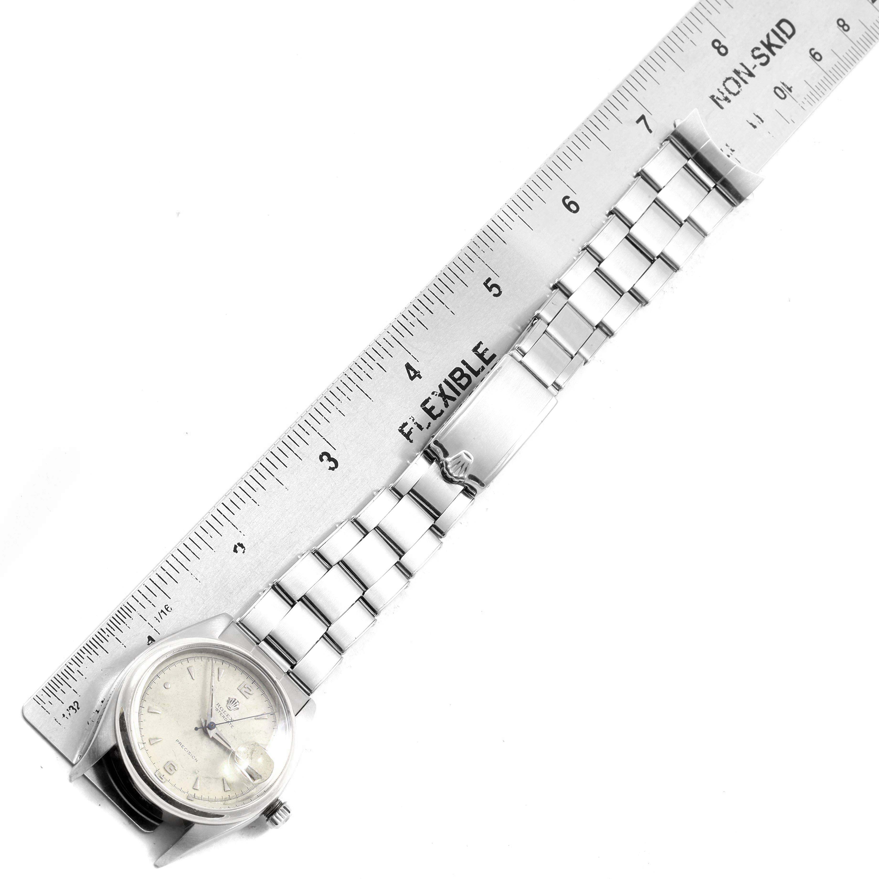 The watch, a Rolex Vintage Collection 6494 Men's Stainless Steel Silver Dial 6494 Men's Stainless Steel Silver Dial model, is shown laid flat with a ruler beside it for scale, displaying the face and bracelet.