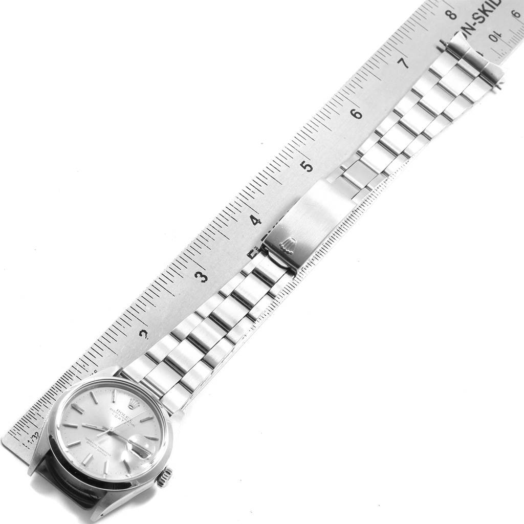 The image shows the Rolex Vintage Collection 15000 Men
s Stainless Steel Silver Dial 15000 Men
s Stainless Steel Silver Dial watch laid flat with a ruler, displaying its face, case, and bracelet.