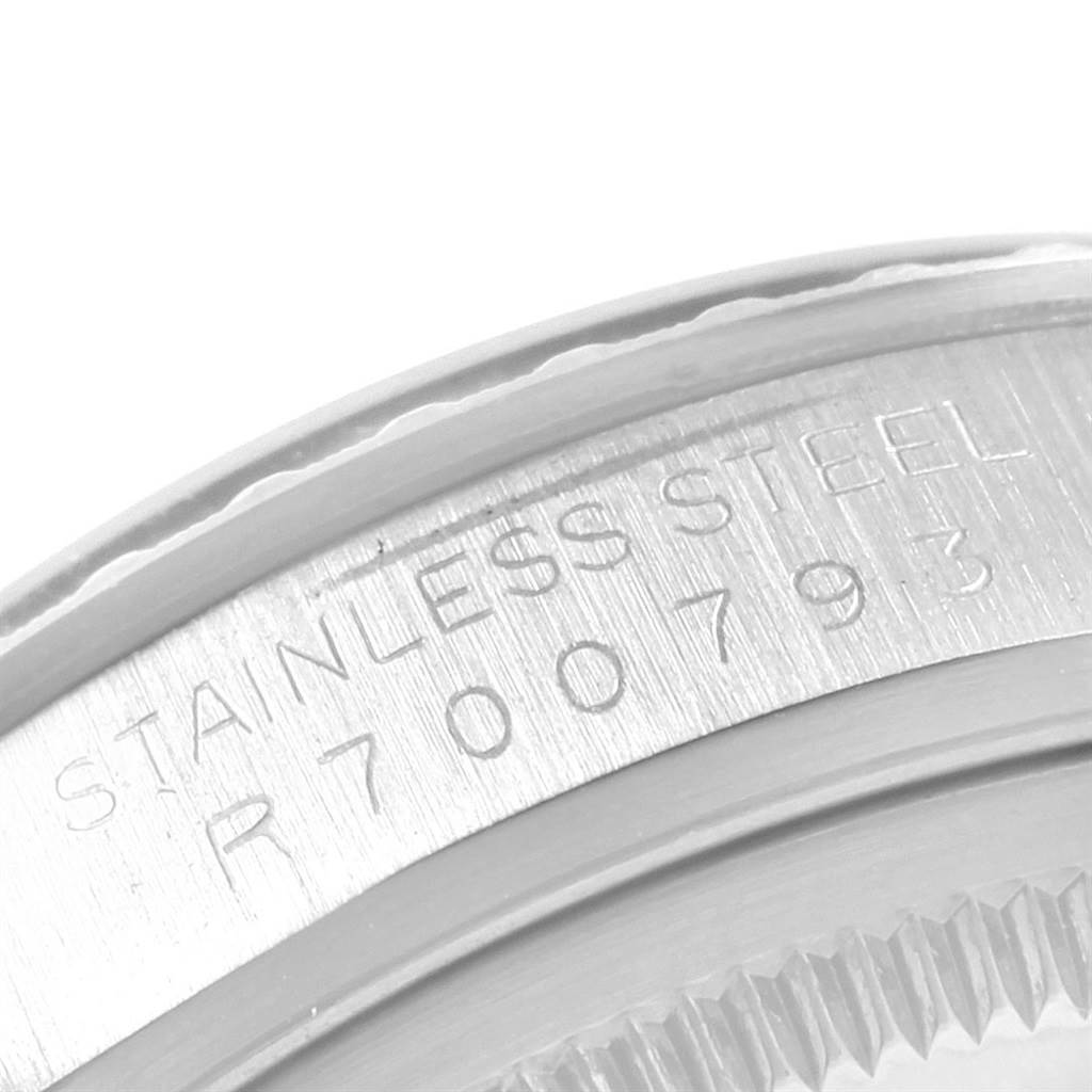 This image shows a close-up of the caseback and edge of the bezel on a Vintage Collection Rolex watch, highlighting the serial number and "STAINLESS STEEL" engraving.
