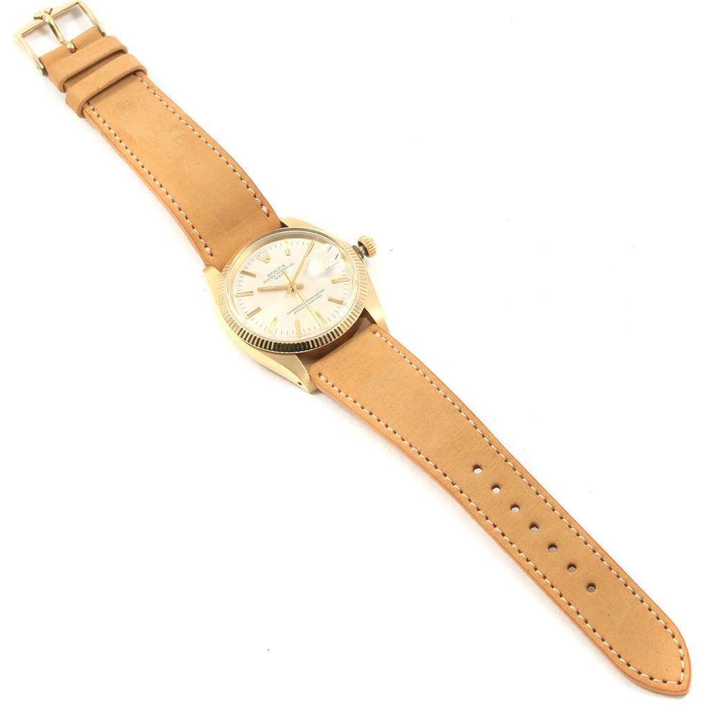 This Rolex Vintage Collection 1501 Men's Yellow Gold Champagne Dial 1501 Men's Yellow Gold Champagne Dial watch is shown from a top-down angle, displaying its face, bezel, crown, and beige leather strap.