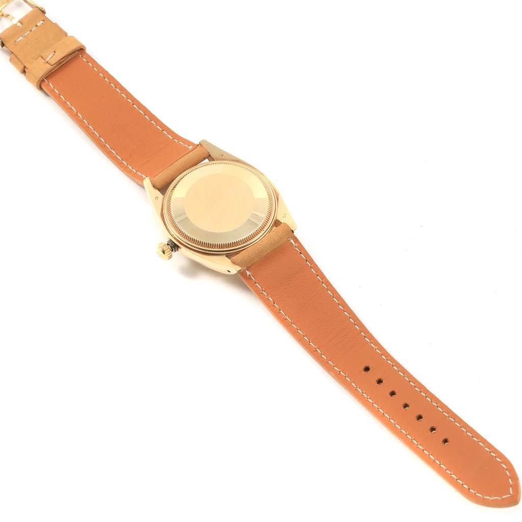 The image shows the back view of the Rolex Vintage Collection 1501 Men's Yellow Gold Champagne Dial 1501 Men's Yellow Gold Champagne Dial watch, including its case and brown leather strap.