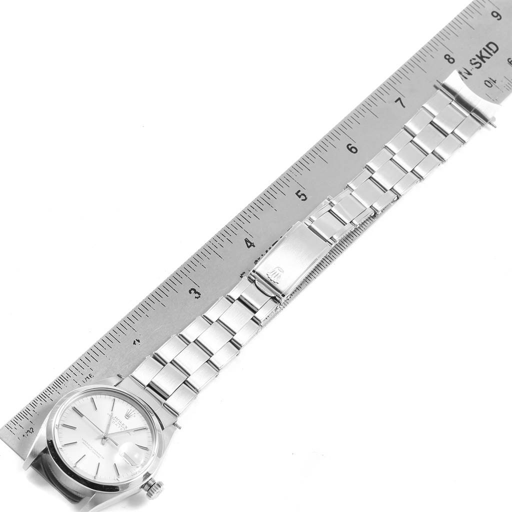 The image shows a top view of the Rolex Vintage Collection 1500 Men's Stainless Steel Silver Dial 1500 Men's Stainless Steel Silver Dial watch, displaying the face, bracelet, and clasp next to a ruler for scale.