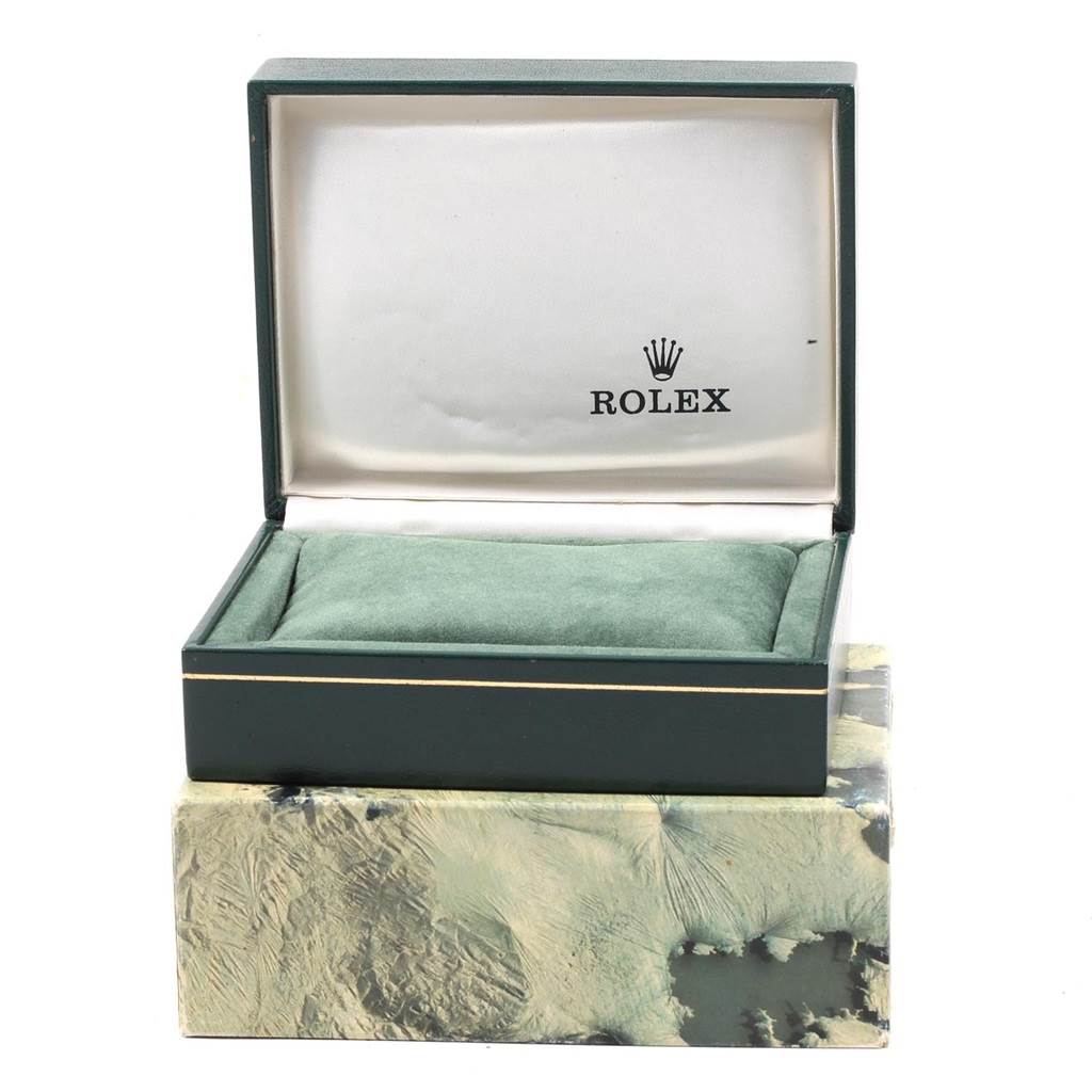 The image shows an open green Rolex watch box, part of the Vintage Collection model, with a cushion inside.