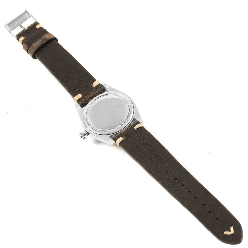 This image shows an overhead view of a Rolex Vintage Collection 6694 Men's Stainless Steel Silver Dial 6694 Men's Stainless Steel Silver Dial watch, highlighting the leather strap and case back.