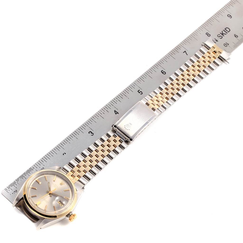 This image shows a top view of a Rolex Vintage Collection 1601 Men
s Steel and Gold (two tone) Grey Dial 1601 Men
s Steel and Gold (two tone) Grey Dial watch, highlighting the face, bezel, and bracelet alongside a ruler.