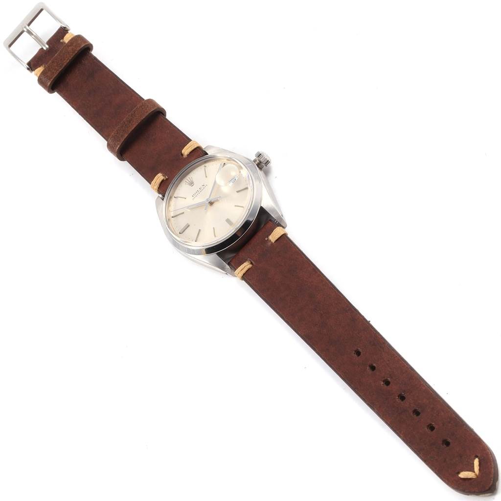 The image shows a top-down view of a Rolex Vintage Collection 6694 Men
s Stainless Steel Silver Dial 6694 Men
s Stainless Steel Silver Dial watch with a brown leather strap and silver case.