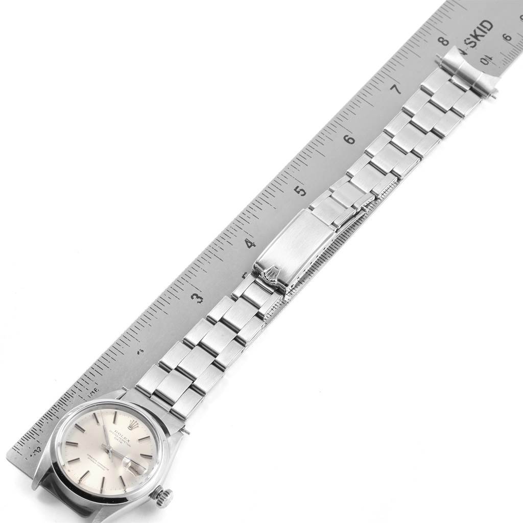 The image shows a Rolex Vintage Collection 1500 Men
s Stainless Steel Silver Dial 1500 Men
s Stainless Steel Silver Dial watch from an overhead angle, displaying the face, bracelet, and clasp, measured against a ruler.