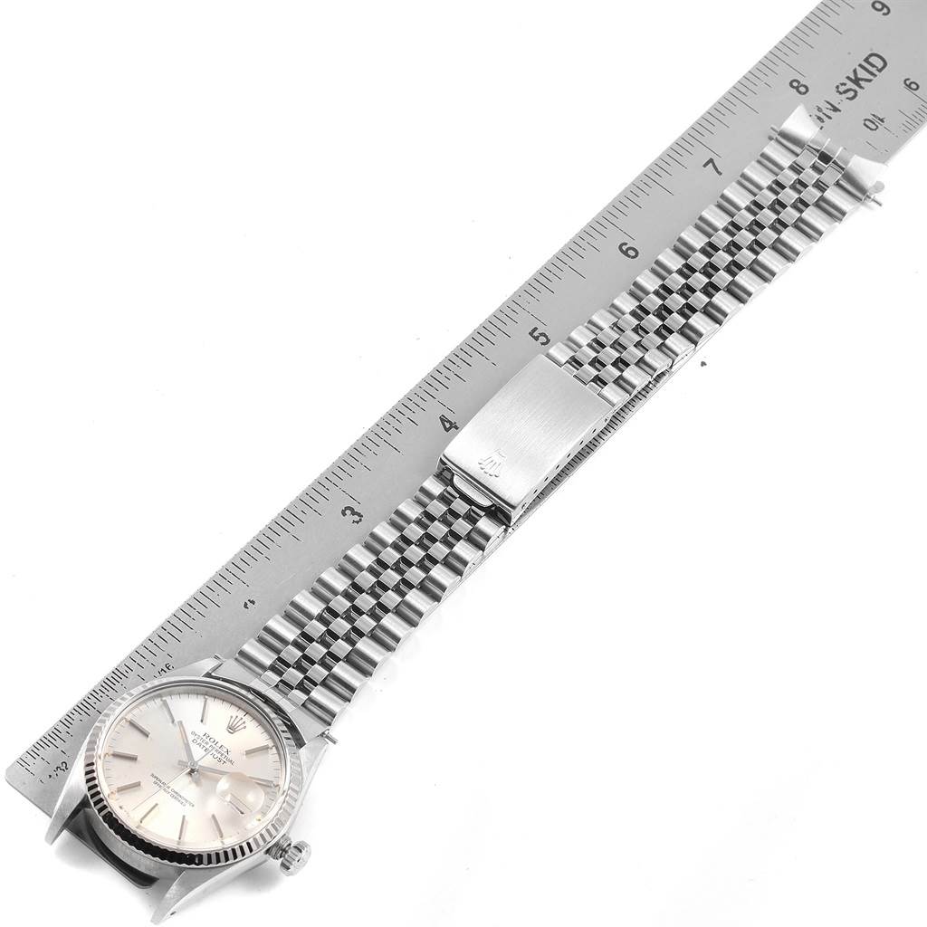 The Rolex Vintage Collection 16014 Men's Stainless Steel Silver Dial 16014 Men's Stainless Steel Silver Dial watch is shown from a top-down angle, displaying the face, bezel, bracelet, and clasp alongside a ruler.