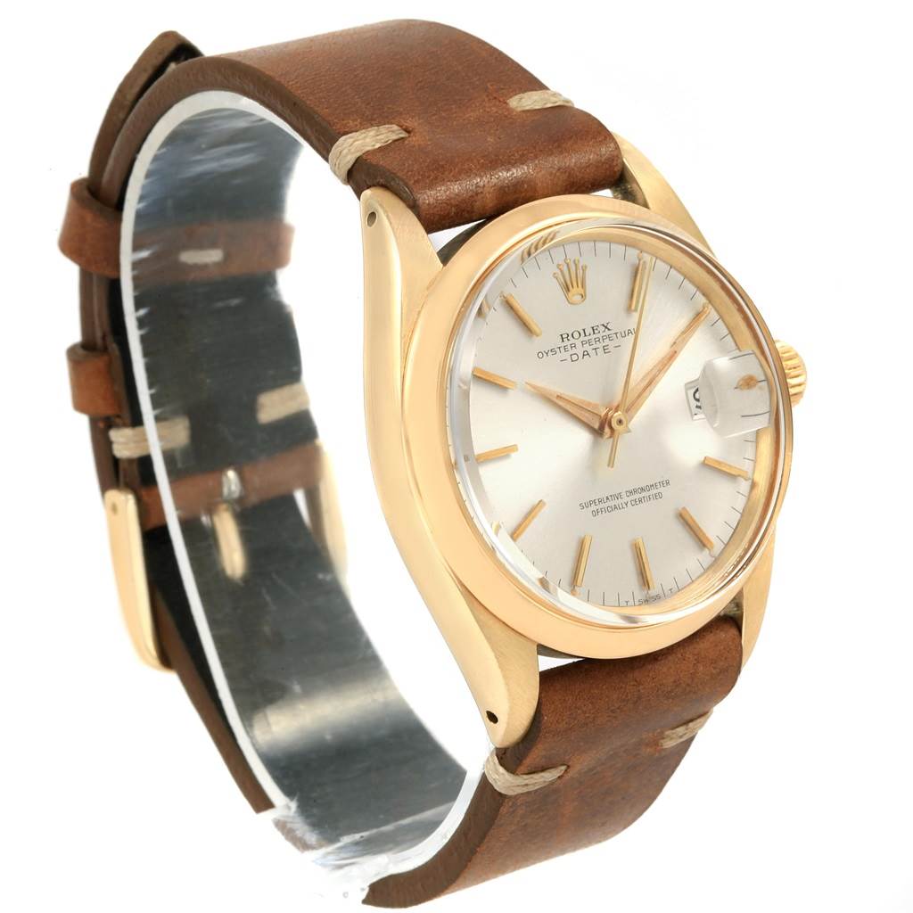 The image shows a Rolex Vintage Collection 1500 Men
s Yellow Gold Silver Dial 1500 Men
s Yellow Gold Silver Dial watch at a slight side angle, highlighting its gold case, leather strap, and dial with date function.