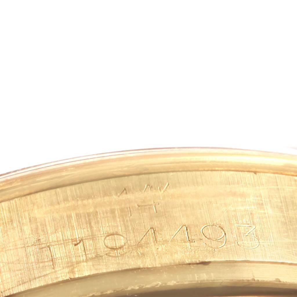 This image shows an angled close-up of the engraved serial numbers on the gold case of a Rolex Vintage Collection 1500 Men
s Yellow Gold Silver Dial 1500 Men
s Yellow Gold Silver Dial model watch.
