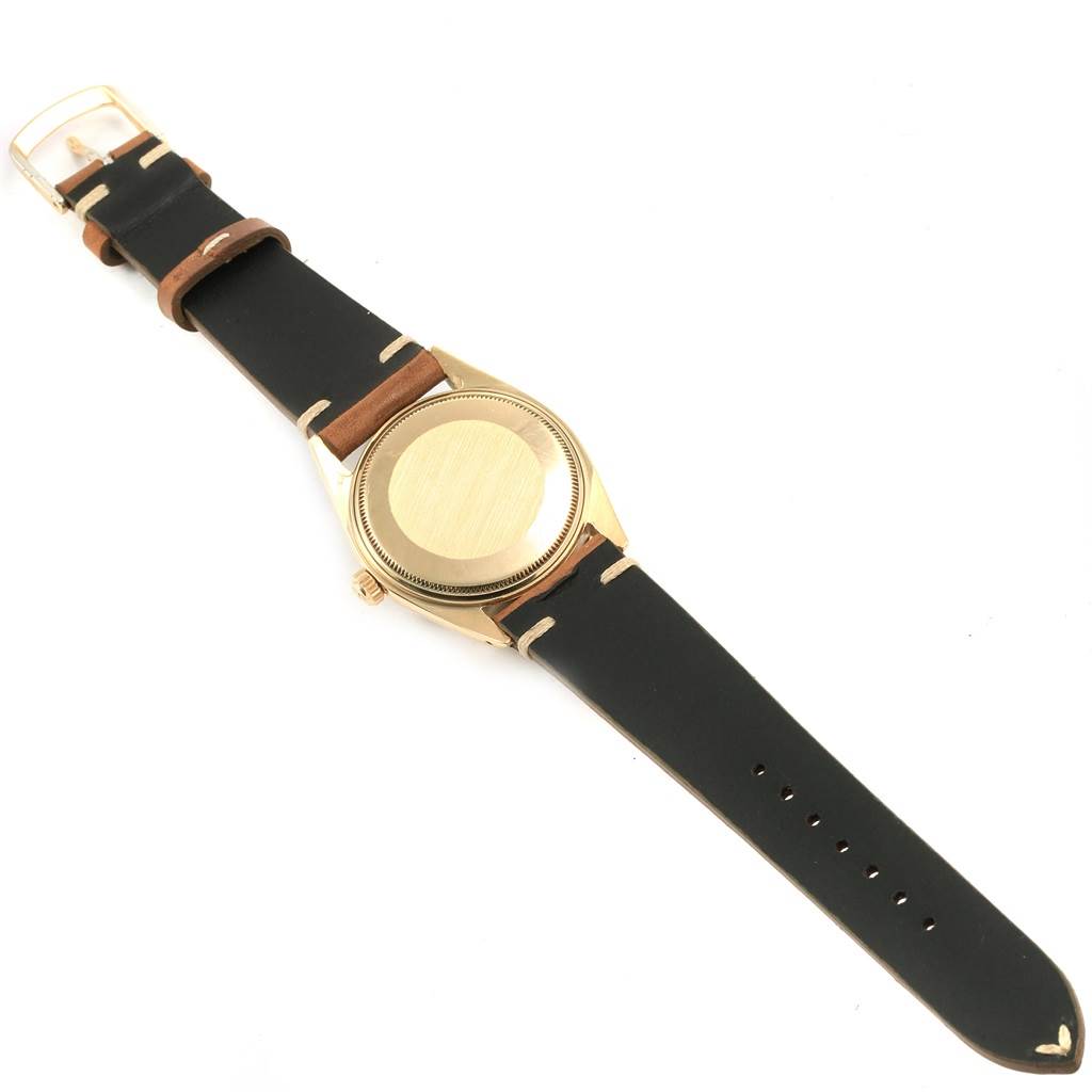 The image shows the back case and straps of a Rolex Vintage Collection 1500 Men
s Yellow Gold Silver Dial 1500 Men
s Yellow Gold Silver Dial model watch from a top-down angle.