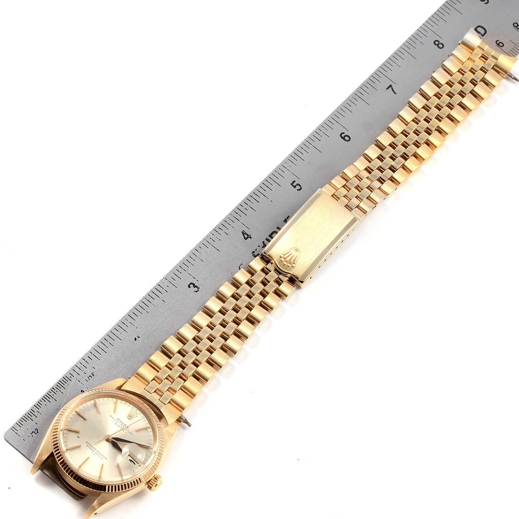 The Rolex Vintage Collection 1500 Men
s Yellow Gold Silver Dial 1500 Men
s Yellow Gold Silver Dial watch is displayed flat next to a ruler, showing the face, clasp, and bracelet.