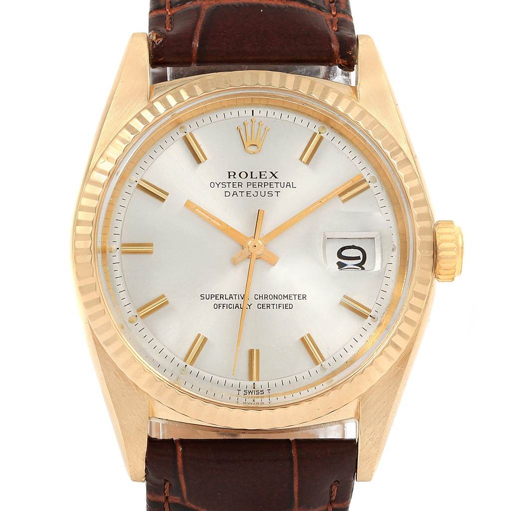 This image shows a front view of the dial and case of a Rolex Vintage Collection 1601 Men
s Yellow Gold Silver Dial 1601 Men
s Yellow Gold Silver Dial Oyster Perpetual Datejust watch, along with part of its leather strap.
