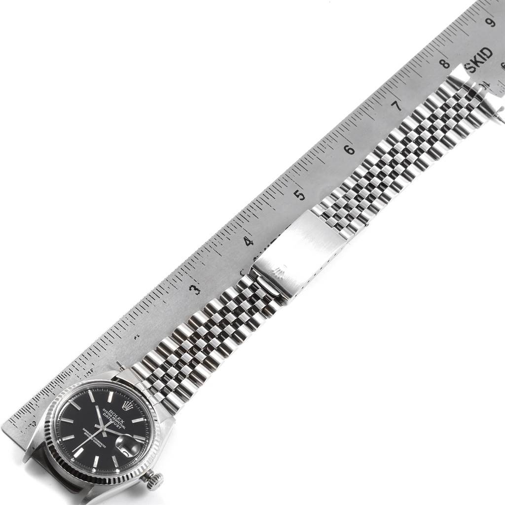 The image shows a top-down view of a Rolex Vintage Collection 1601 Men's Stainless Steel Black Dial 1601 Men's Stainless Steel Black Dial watch, displaying its face, bracelet, and clasp with a measuring ruler.