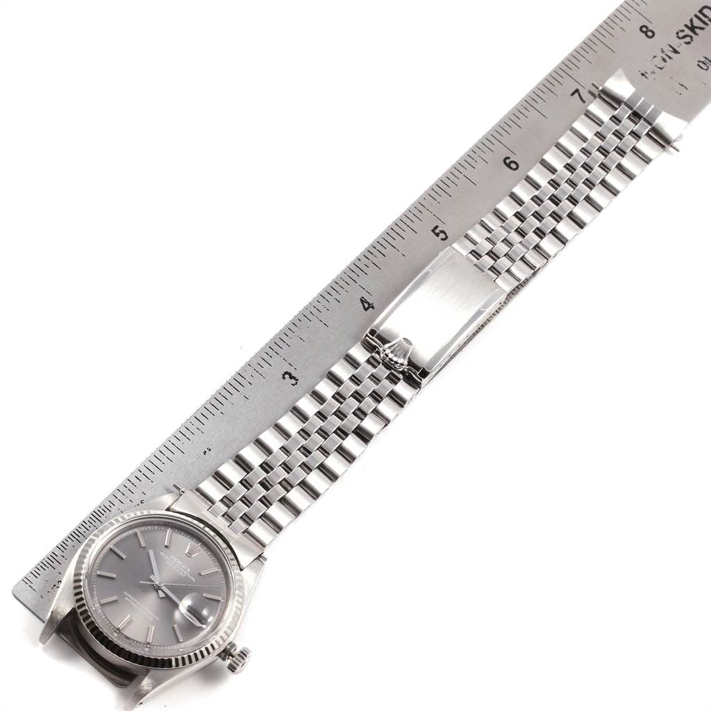 The image shows a Rolex Vintage Collection 1601 Men's Stainless Steel Grey Dial 1601 Men's Stainless Steel Grey Dial watch laid flat next to a ruler, highlighting the watch face and bracelet.