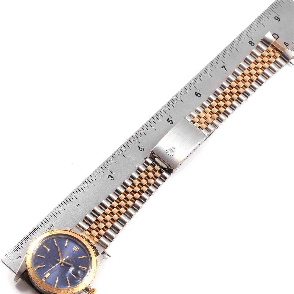 The image shows a Rolex Vintage Collection 16253 Men's Steel and Gold (two tone) Blue Dial 16253 Men's Steel and Gold (two tone) Blue Dial watch from above, highlighting its blue dial, gold bezel, and two-tone bracelet next to a ruler.