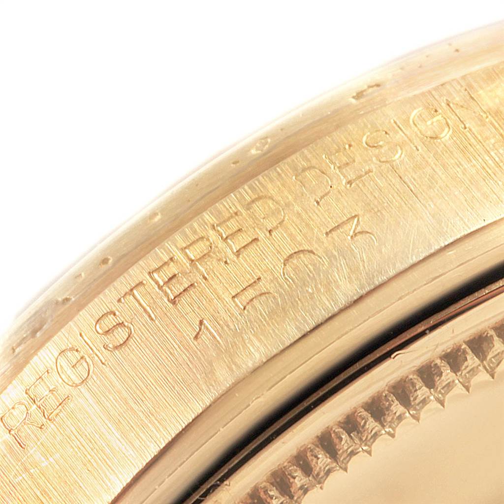 This image shows a close-up angle of the side of the case and bezel of a Rolex Vintage Collection 1503 Men
s Yellow Gold Blue Dial 1503 Men
s Yellow Gold Blue Dial model watch with engraved text.
