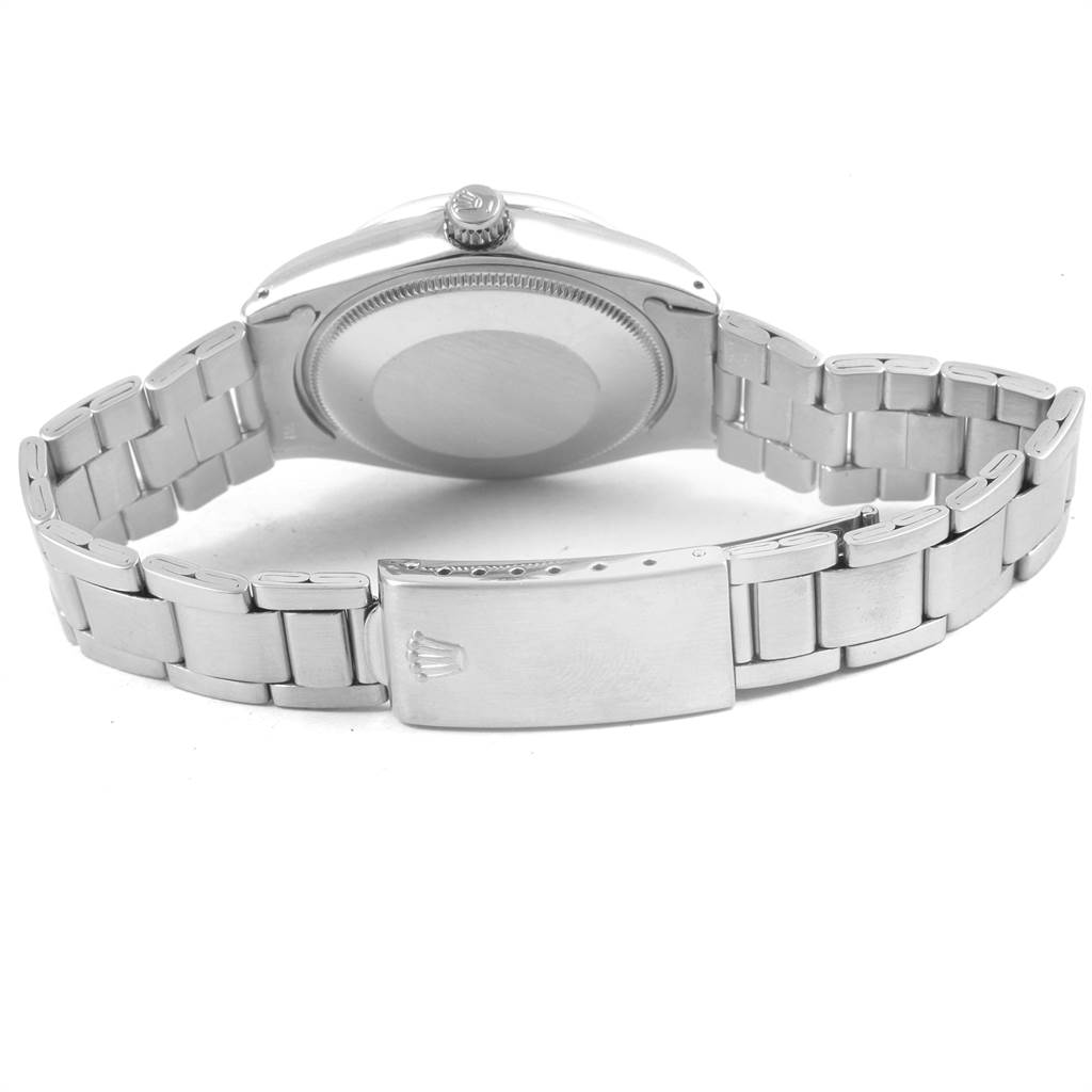 The image shows the back of a Vintage Collection Rolex watch, including its case back, crown, and metal bracelet.