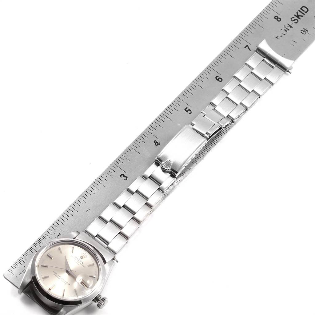 The image shows a Rolex Vintage Collection 1500 Men's Stainless Steel Silver Dial 1500 Men's Stainless Steel Silver Dial watch laid flat alongside a ruler, displaying the watch face and bracelet.