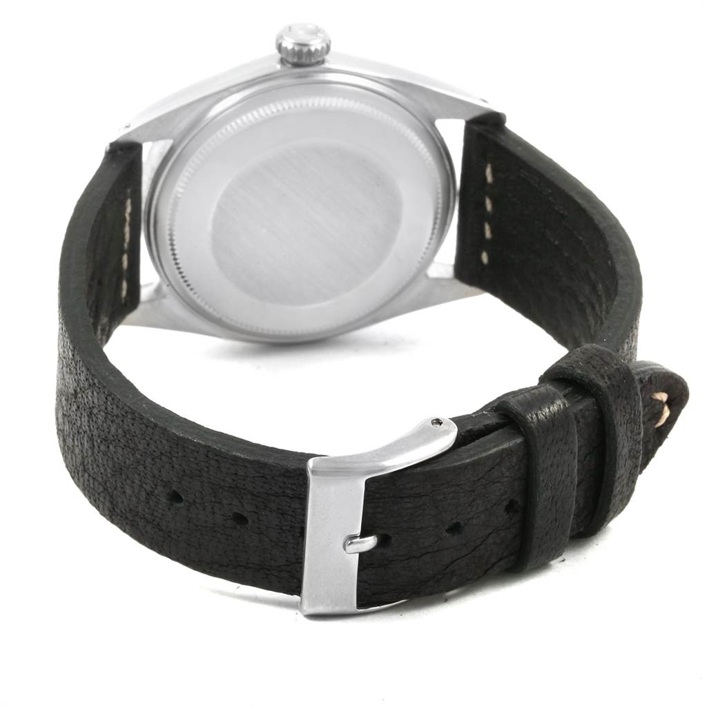 The image shows the back view of a Rolex Vintage Collection 1601 Men's Stainless Steel Silver Dial 1601 Men's Stainless Steel Silver Dial watch, highlighting its case, crown, and leather strap with buckle.