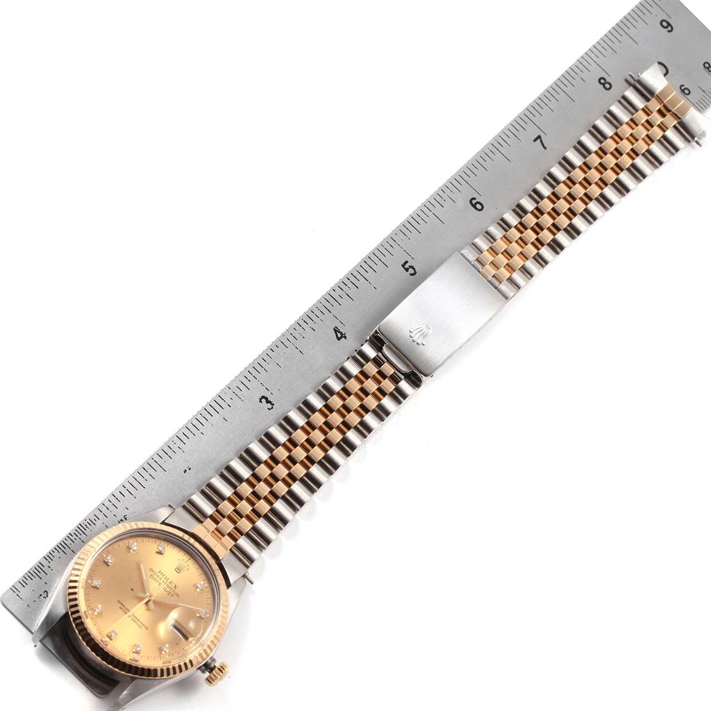 The image shows a full-length, top-down view of a Rolex Vintage Collection 16013 Men's Stainless Steel Champagne Dial 16013 Men's Stainless Steel Champagne Dial watch, positioned next to a ruler.