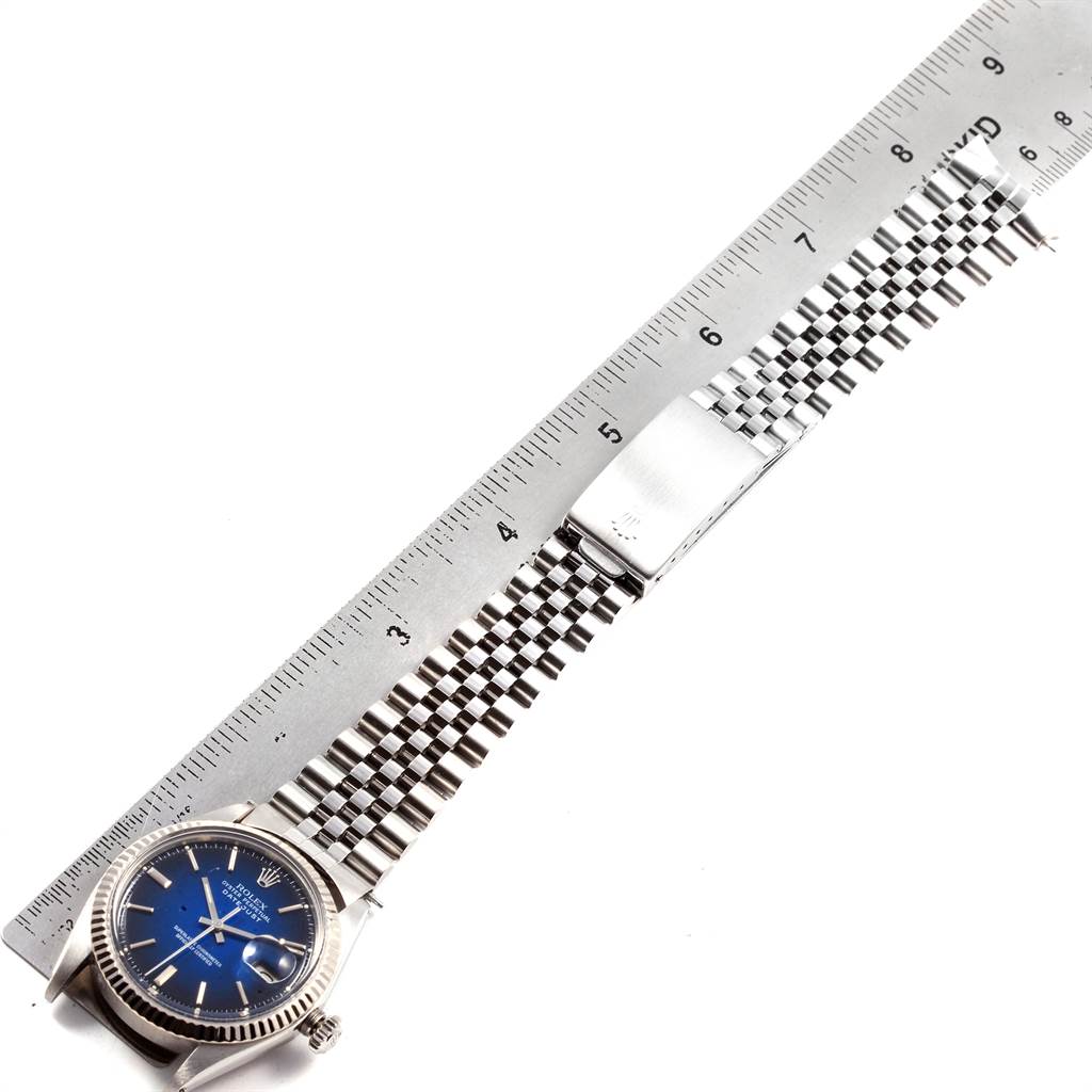 The image shows the side view of the Rolex Vintage Collection 1601 Men's Stainless Steel Blue Dial 1601 Men's Stainless Steel Blue Dial watch with a blue dial and stainless steel bracelet against a ruler.