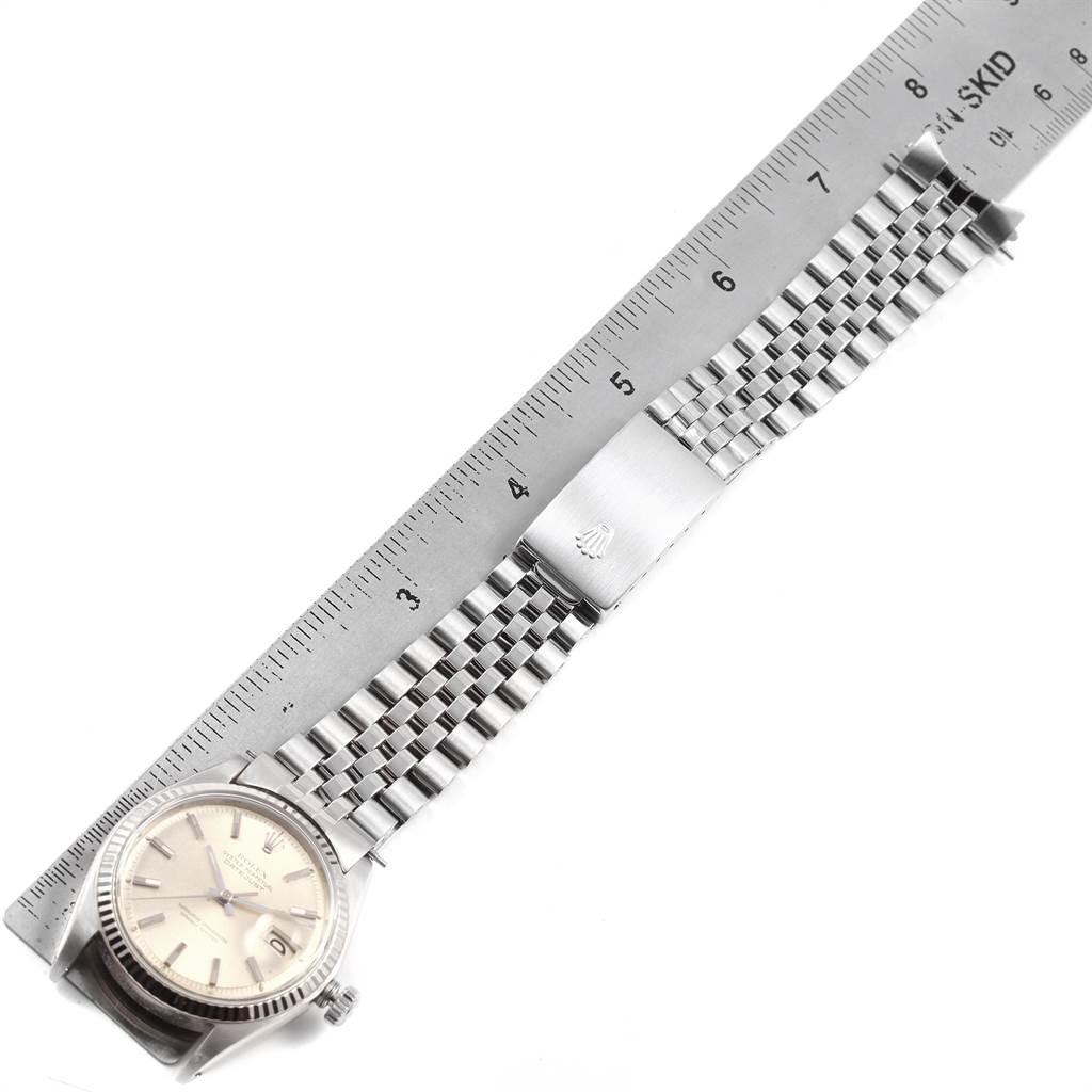 The image shows a Rolex Vintage Collection 1601 Men's Stainless Steel Silver Dial 1601 Men's Stainless Steel Silver Dial watch lying beside a ruler, with the face and full-length bracelet fully visible.