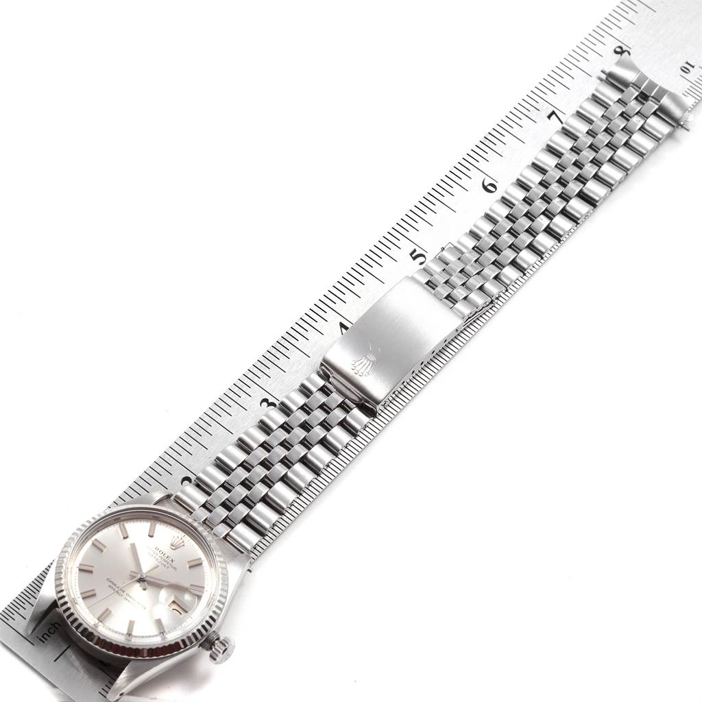 The Rolex Vintage Collection 1601 Men's Stainless Steel Silver Dial 1601 Men's Stainless Steel Silver Dial watch is shown from a top-down angle, highlighting its face, bracelet, and clasp alongside a measuring ruler.