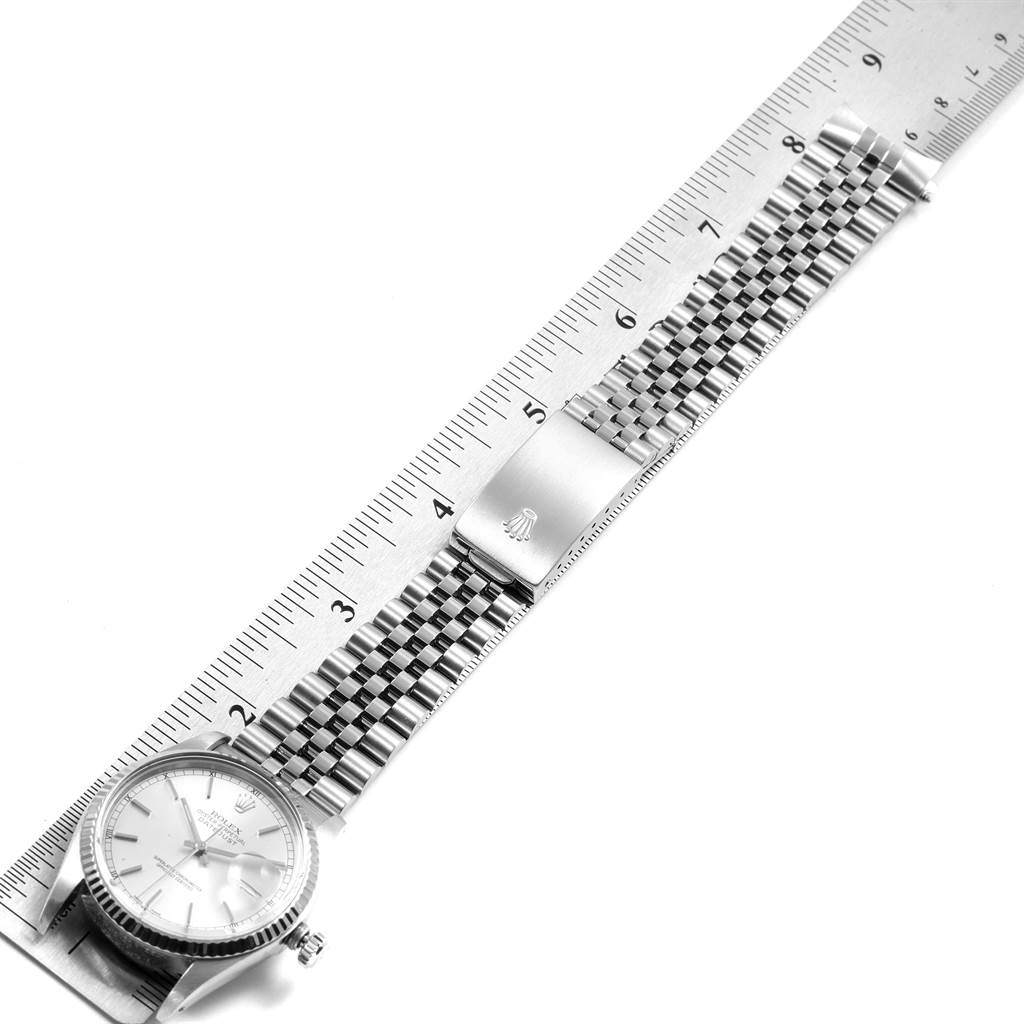 The image shows a Rolex Vintage Collection 16014 Men's Stainless Steel Silver Dial 16014 Men's Stainless Steel Silver Dial watch with its face and metal bracelet laid alongside a ruler for measurement.