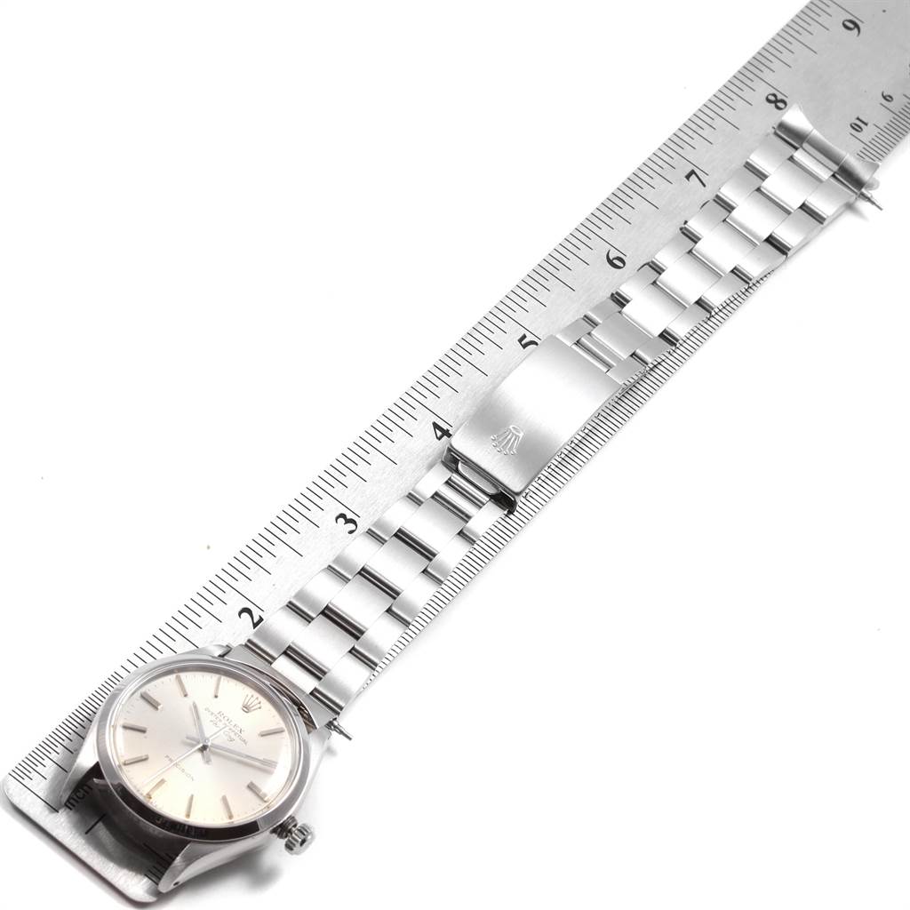 The image shows the Rolex Vintage Collection 5500 Men
s Stainless Steel Silver Dial 5500 Men
s Stainless Steel Silver Dial watch lying flat with a stainless steel bracelet on a measuring ruler.