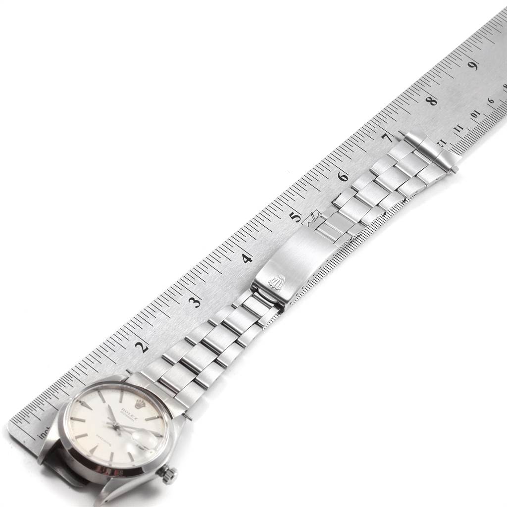 This image shows the Rolex Vintage Collection 6694 Men
s Stainless Steel Silver Dial 6694 Men
s Stainless Steel Silver Dial watch displayed flat alongside a ruler, highlighting its band and clasp.