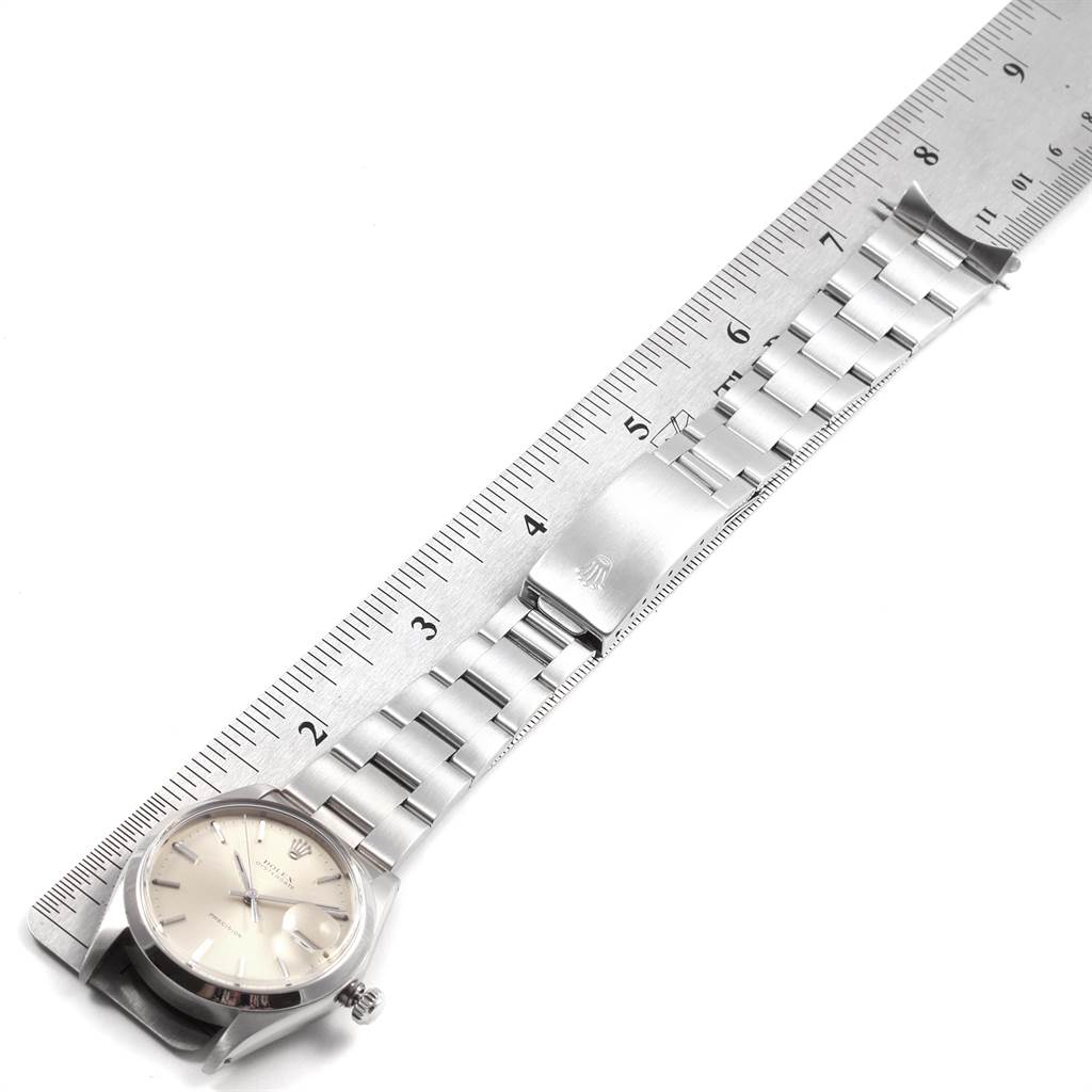 The image shows a Rolex Vintage Collection 6694 Men
s Stainless Steel Silver Dial 6694 Men
s Stainless Steel Silver Dial watch laid out flat with a ruler, displaying both the face and band.