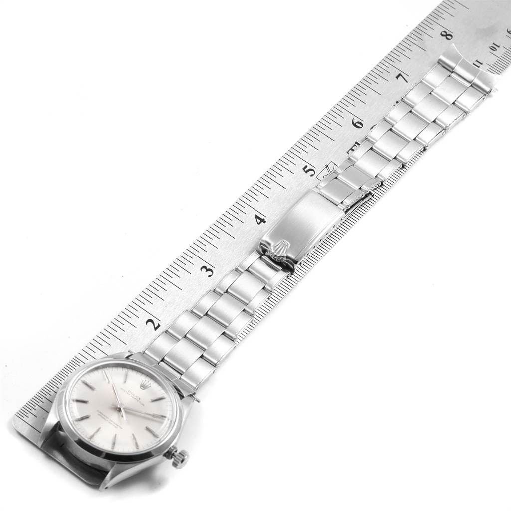 The image shows a Rolex Vintage Collection 1002 Men
s Stainless Steel Silver Dial 1002 Men
s Stainless Steel Silver Dial model watch laid flat, aligned with a ruler, highlighting its clasp and stainless steel bracelet.