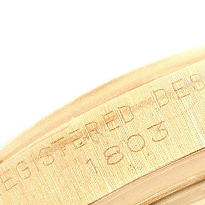 The image shows a close-up of the engraved edge of the Rolex Vintage Collection 1803 Men
s Yellow Gold Silver Dial 1803 Men
s Yellow Gold Silver Dial watch case.