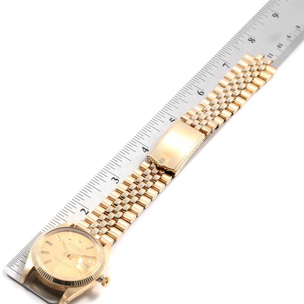 The image shows a Rolex Vintage Collection 1503 Men
s Yellow Gold Champagne Dial 1503 Men
s Yellow Gold Champagne Dial watch with a gold strap lying next to a ruler for measurement.