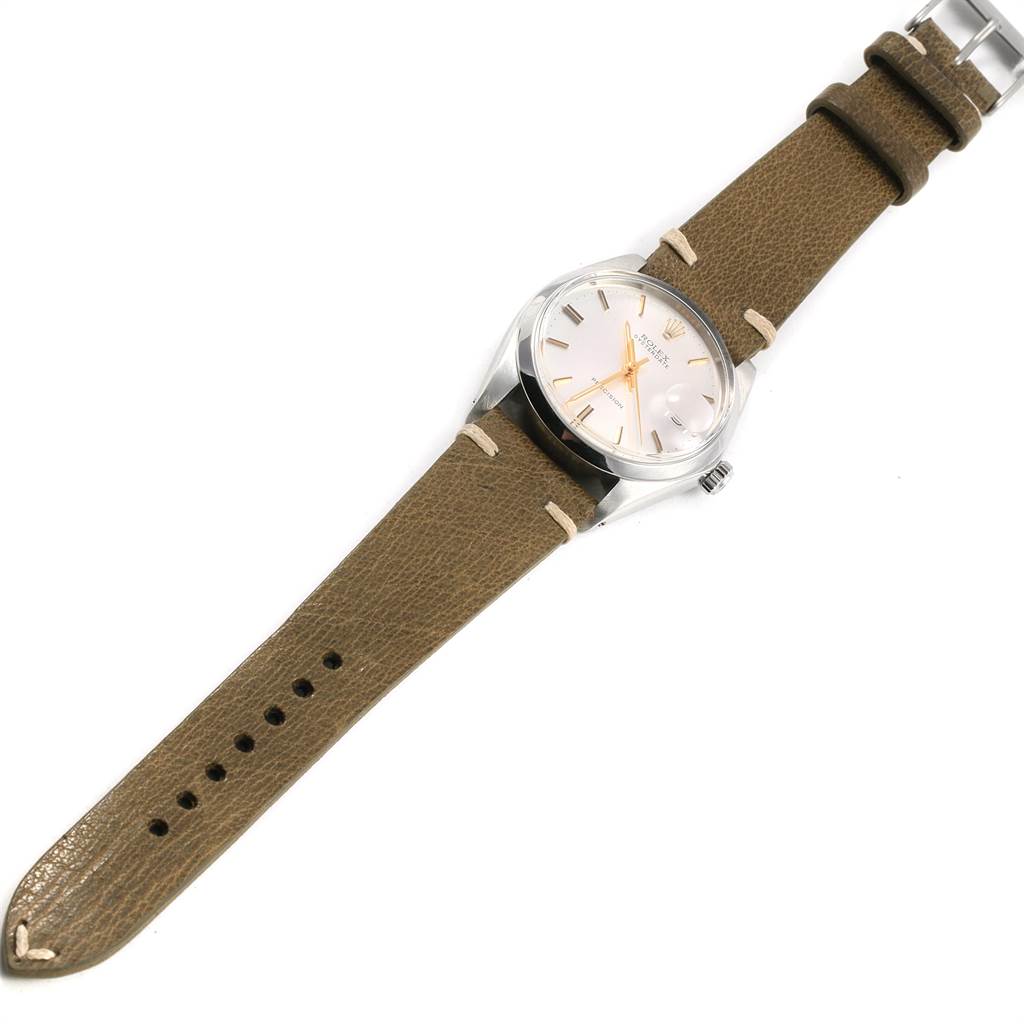 The Rolex Vintage Collection 6694 Men
s Stainless Steel Silver Dial 6694 Men
s Stainless Steel Silver Dial watch is shown from a top-down angle, displaying its dial, bezel, case, crown, and leather strap.